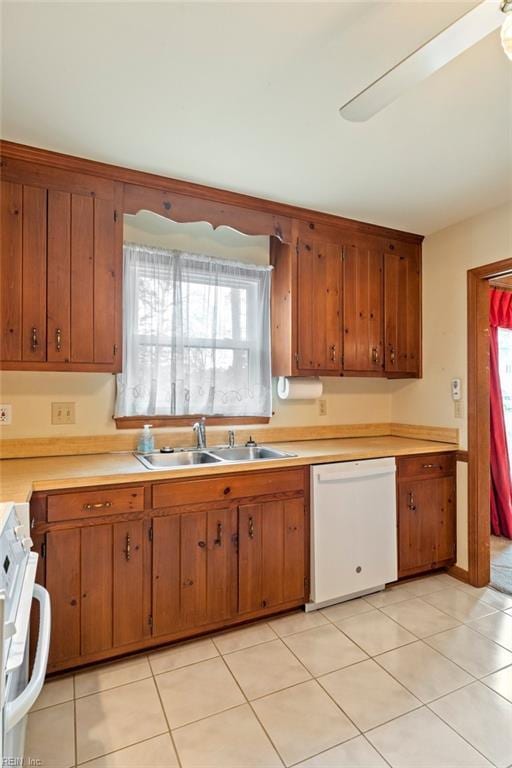 kitchen with dishwasher, sink, range, and light tile patterned flooring