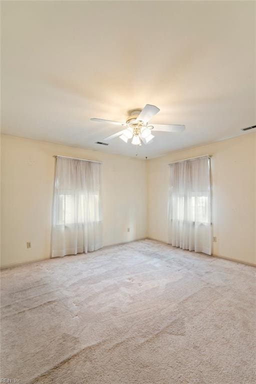 carpeted spare room featuring ceiling fan