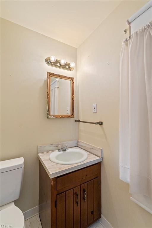 bathroom featuring tile patterned flooring, vanity, and toilet