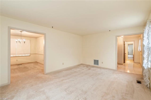 empty room featuring an inviting chandelier and carpet