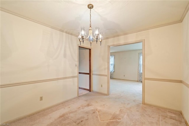 carpeted spare room with ornamental molding and a chandelier