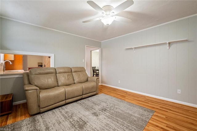 living room featuring crown molding, sink, hardwood / wood-style floors, and ceiling fan