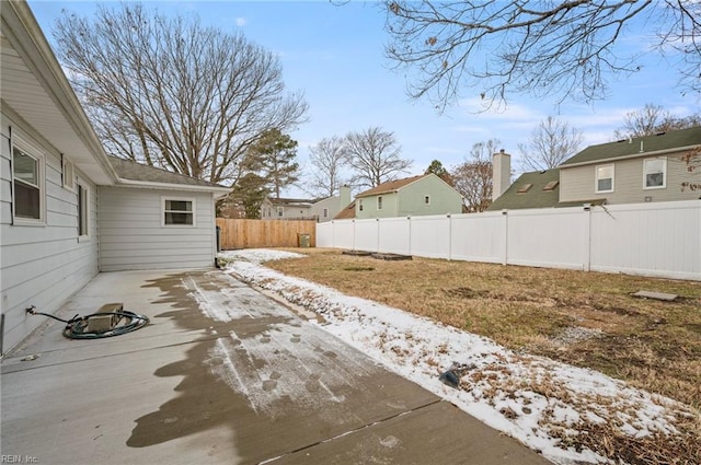 yard layered in snow with a patio area