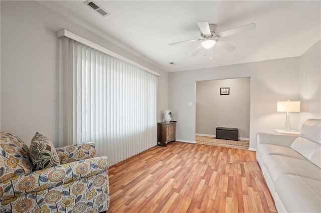 living room with ceiling fan and light wood-type flooring