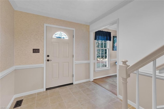 tiled foyer featuring ornamental molding