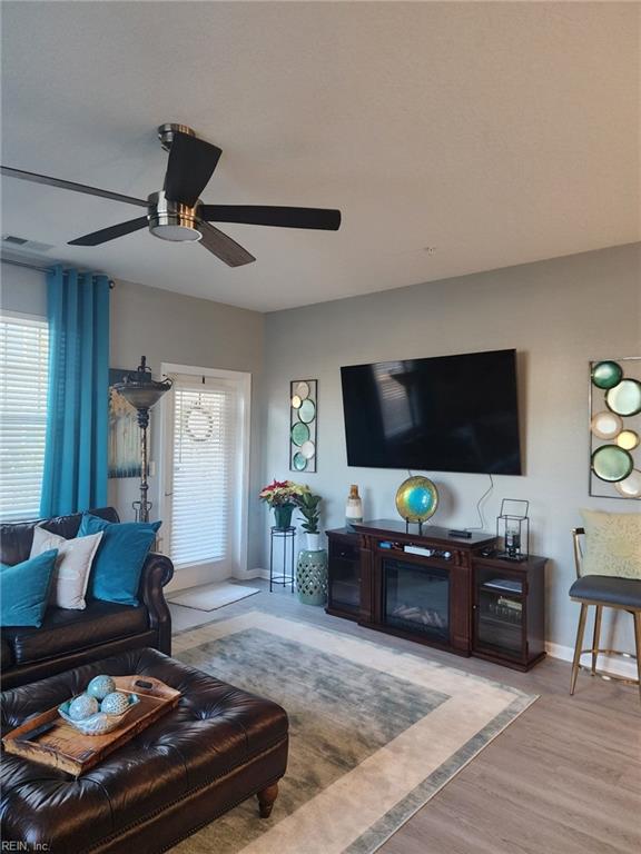 living room featuring ceiling fan, a wealth of natural light, and light hardwood / wood-style floors