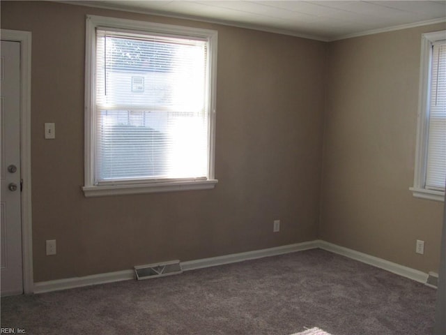 unfurnished room featuring dark colored carpet and crown molding