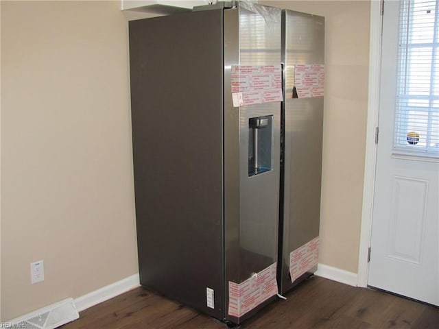 room details featuring wood-type flooring and stainless steel fridge