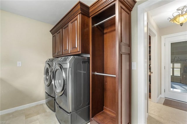 laundry room featuring washer and dryer, cabinet space, baseboards, and light tile patterned floors