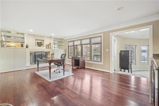 office area featuring baseboards, hardwood / wood-style floors, and crown molding