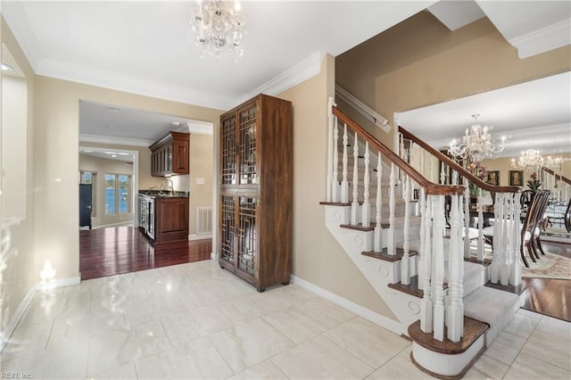 staircase featuring crown molding and a chandelier