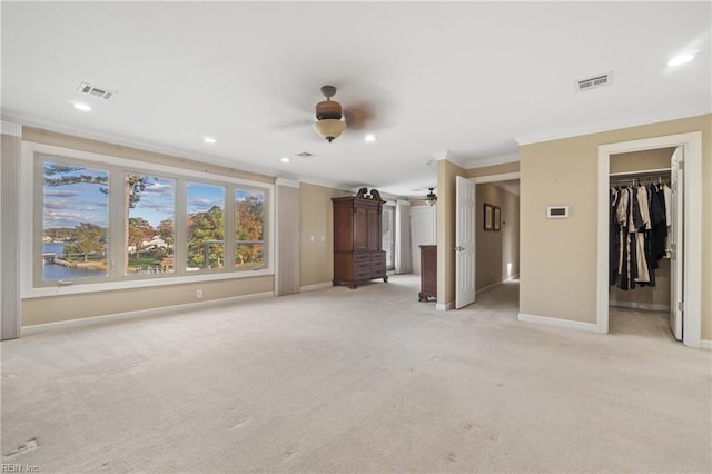 unfurnished living room with ornamental molding, light carpet, and ceiling fan