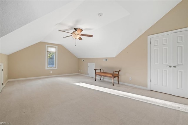 additional living space featuring lofted ceiling, light carpet, ceiling fan, and baseboards