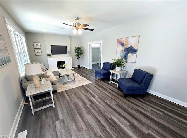 living room with dark wood-type flooring and ceiling fan