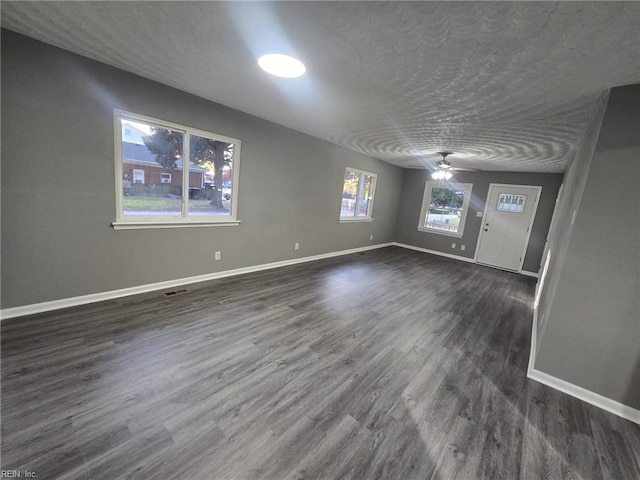 interior space with dark wood-type flooring, ceiling fan, and a textured ceiling