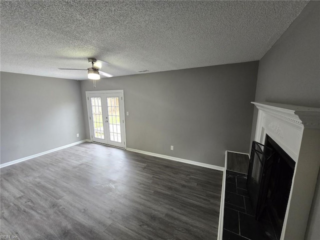 unfurnished living room featuring french doors, ceiling fan, dark wood-type flooring, and a textured ceiling