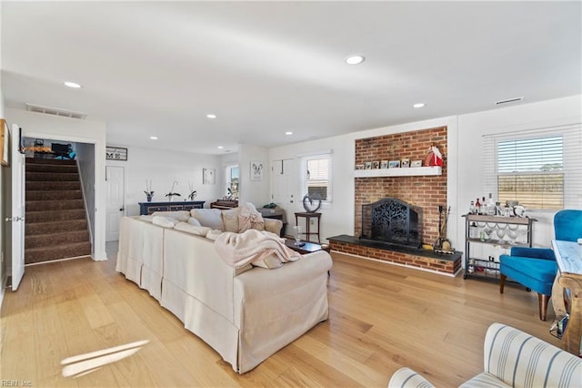 living room featuring light hardwood / wood-style floors and a brick fireplace