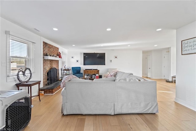 living room with a fireplace and light wood-type flooring