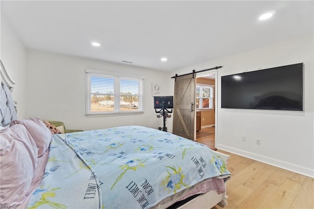 bedroom with hardwood / wood-style flooring and a barn door