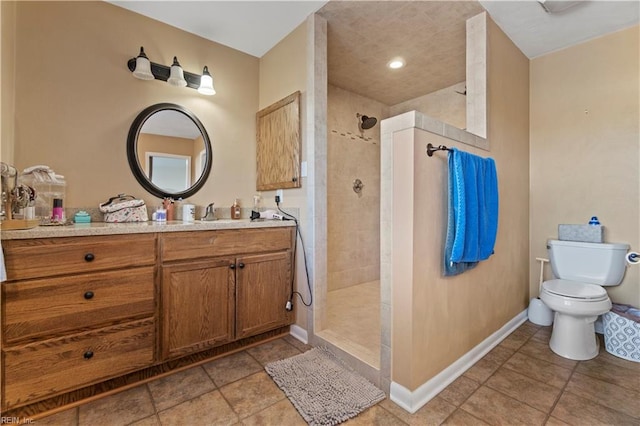 bathroom featuring tiled shower, vanity, and toilet