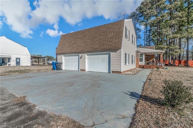 view of side of property with a garage, an outdoor structure, and covered porch