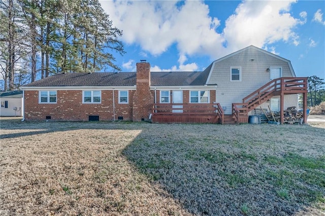 rear view of house featuring a wooden deck and a lawn