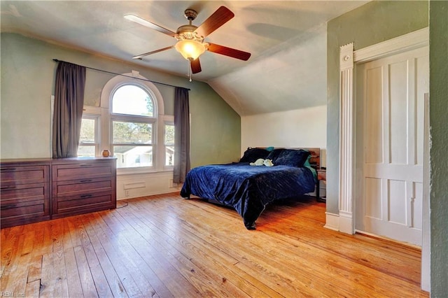 bedroom featuring lofted ceiling, ceiling fan, and light wood-type flooring