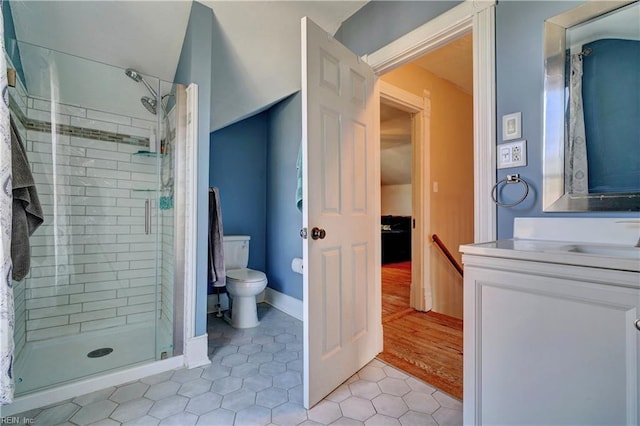 bathroom with tile patterned flooring, vanity, toilet, and walk in shower