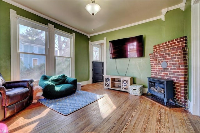 living room featuring hardwood / wood-style flooring, ornamental molding, and a wood stove