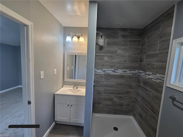 bathroom with vanity and tiled shower