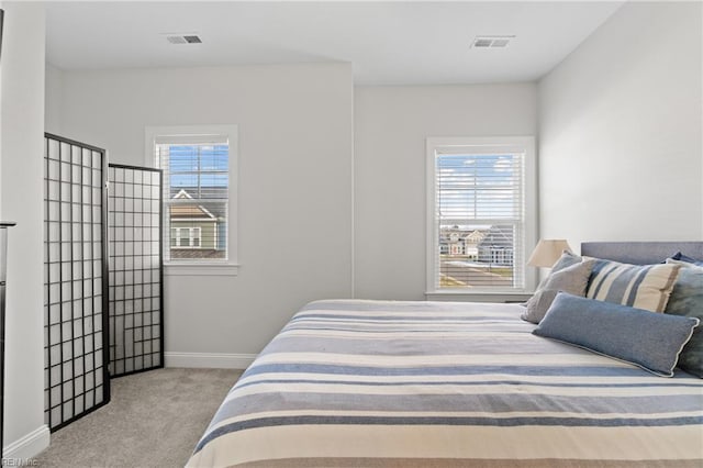 carpeted bedroom featuring multiple windows