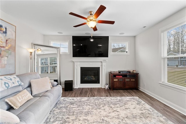 living room featuring dark wood-type flooring and ceiling fan