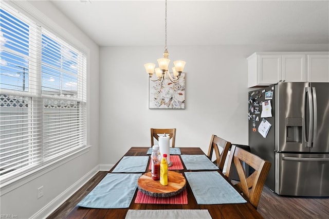 dining space featuring dark hardwood / wood-style floors and a chandelier