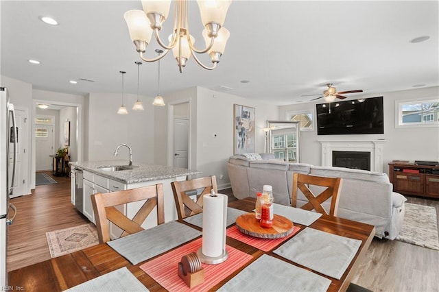 dining area with ceiling fan, plenty of natural light, sink, and light hardwood / wood-style floors