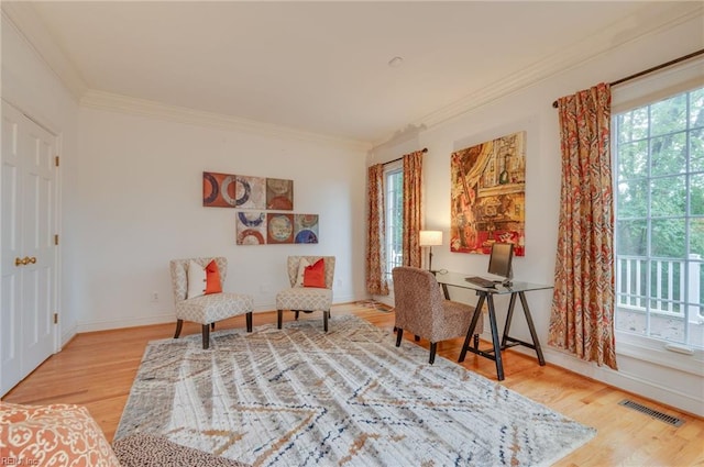 sitting room with hardwood / wood-style floors and crown molding