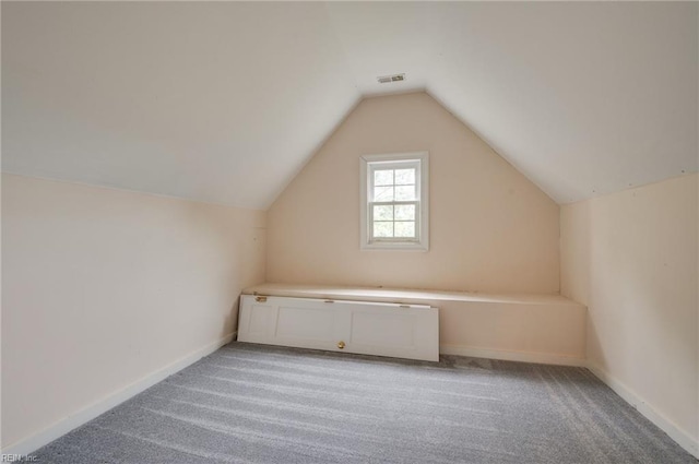 additional living space featuring vaulted ceiling and light carpet