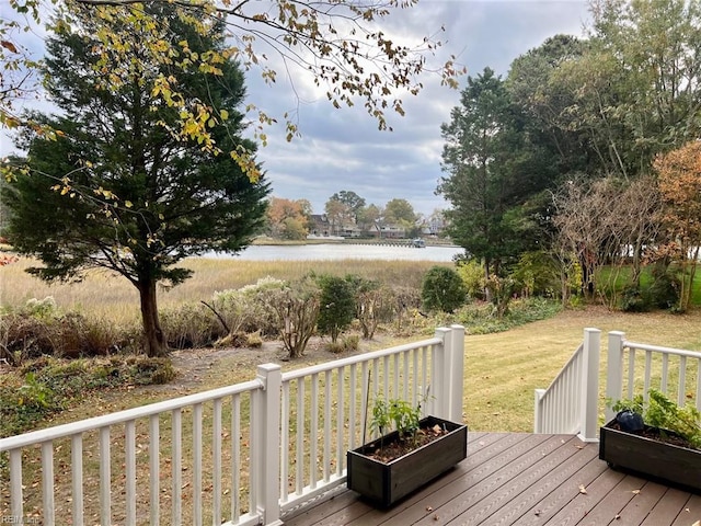 wooden deck with a water view and a yard