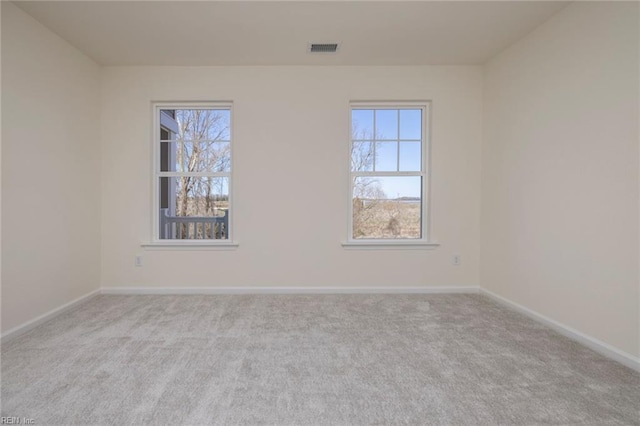 carpeted spare room featuring a wealth of natural light