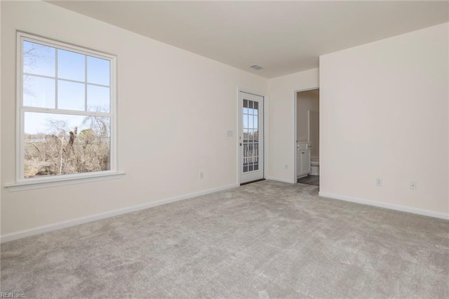 unfurnished room featuring light carpet