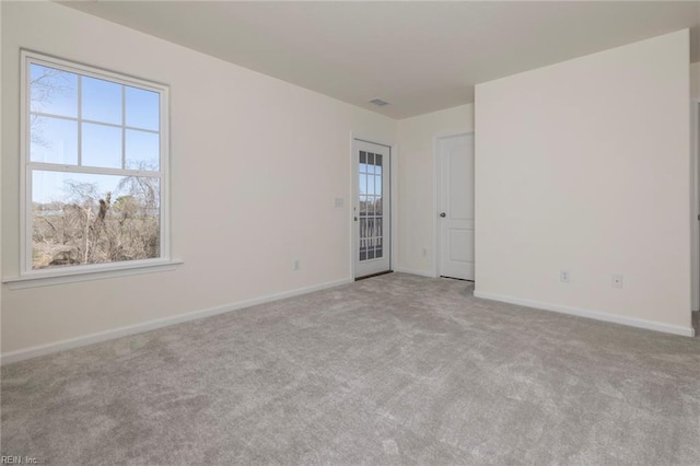 spare room featuring light carpet and a wealth of natural light