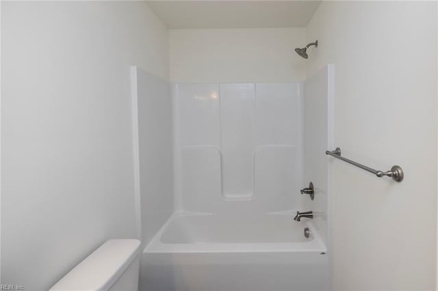 bathroom with bathing tub / shower combination and toilet