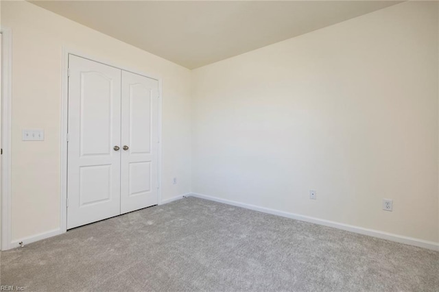 unfurnished bedroom with light carpet and a closet