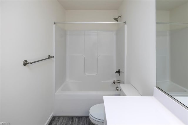 bathroom featuring hardwood / wood-style flooring, shower / bathtub combination, and toilet