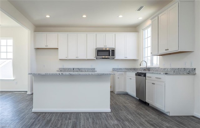 kitchen featuring white cabinetry, a kitchen island, and appliances with stainless steel finishes