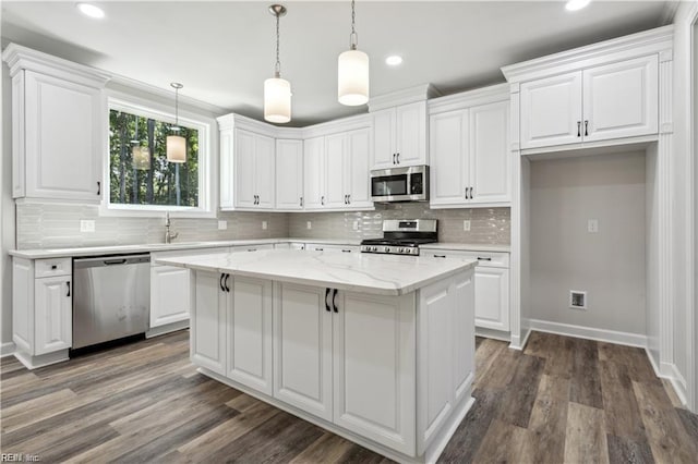 kitchen with a kitchen island, dark hardwood / wood-style floors, white cabinets, light stone counters, and stainless steel appliances