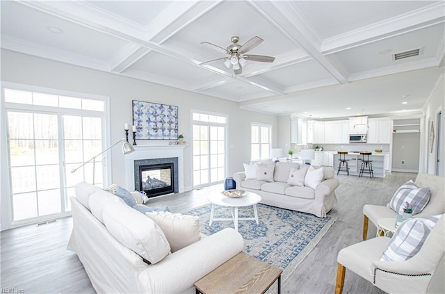 living room featuring coffered ceiling, beamed ceiling, and light wood-type flooring