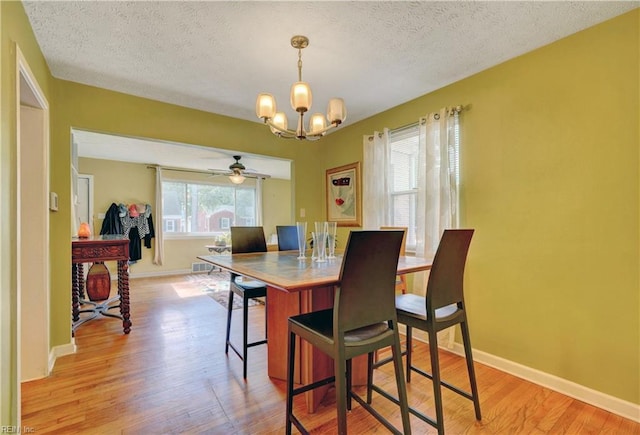 dining room with a healthy amount of sunlight, a notable chandelier, and light hardwood / wood-style floors