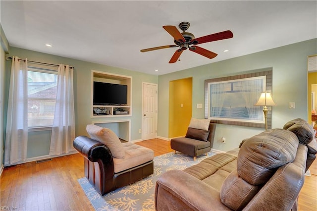 living room with ceiling fan and light wood-type flooring