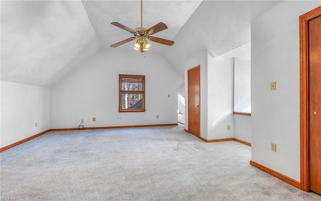 additional living space with vaulted ceiling, light carpet, and ceiling fan