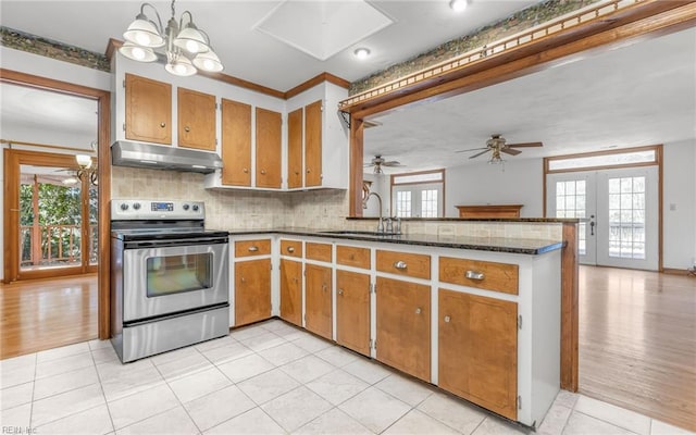 kitchen with sink, electric range, kitchen peninsula, a healthy amount of sunlight, and french doors